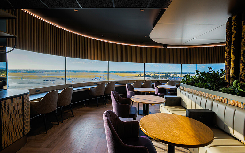 Interior of Aspire Lounge dining area overlooking the runway