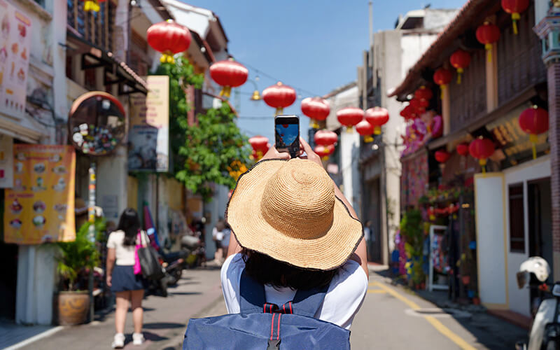 Woman taking photos of a street in Georgetown, Penang